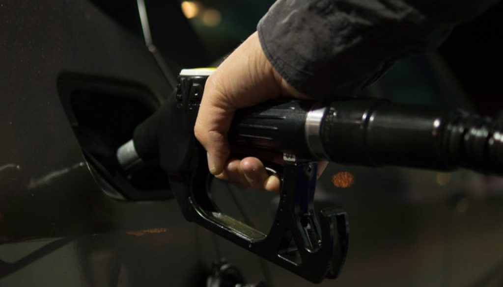 man filling gas tank after pouring in best fuel system cleaners available today