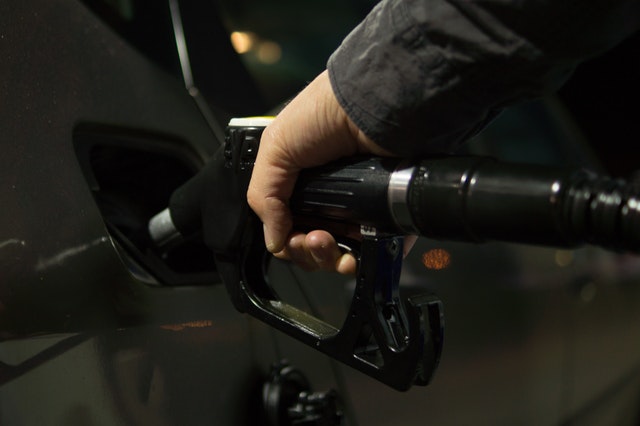 man filling gas tank after pouring in best fuel system cleaners available today