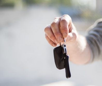 man handing over car keys with questions to ask when buying a used car